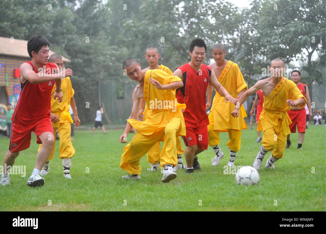 Young Chinese monks from Shaolin Temple Tagou Wushu School compete with Chinese soccer fans during a football match in Zhengzhou, central Chinas Henan Stock Photo