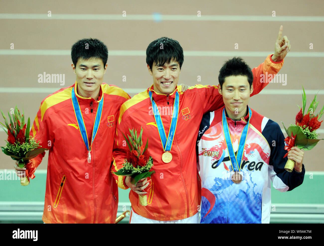 (From left) Silver medalist Shi Dongpeng of China, gold medalist Liu Xiang of China and bronze medalist Park Taekyong of South Korea pose on the podiu Stock Photo