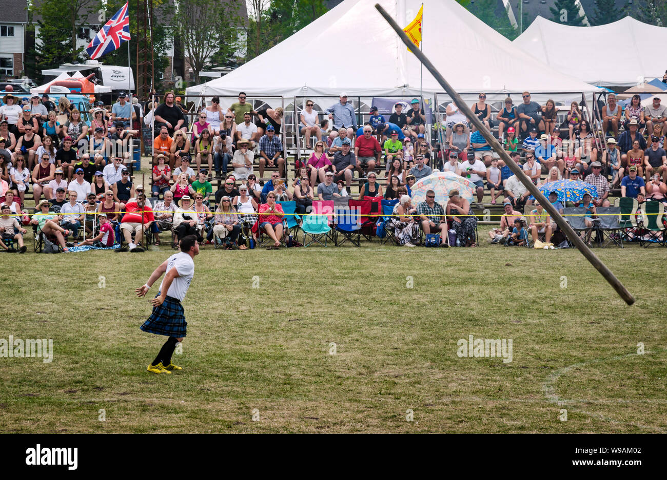 Fergus, Ontario, Canada - 08 11 2018: Traditional Scottish heavies competitions athlete wearing kilt is demonstrating his skills in a Caber Toss conte Stock Photo