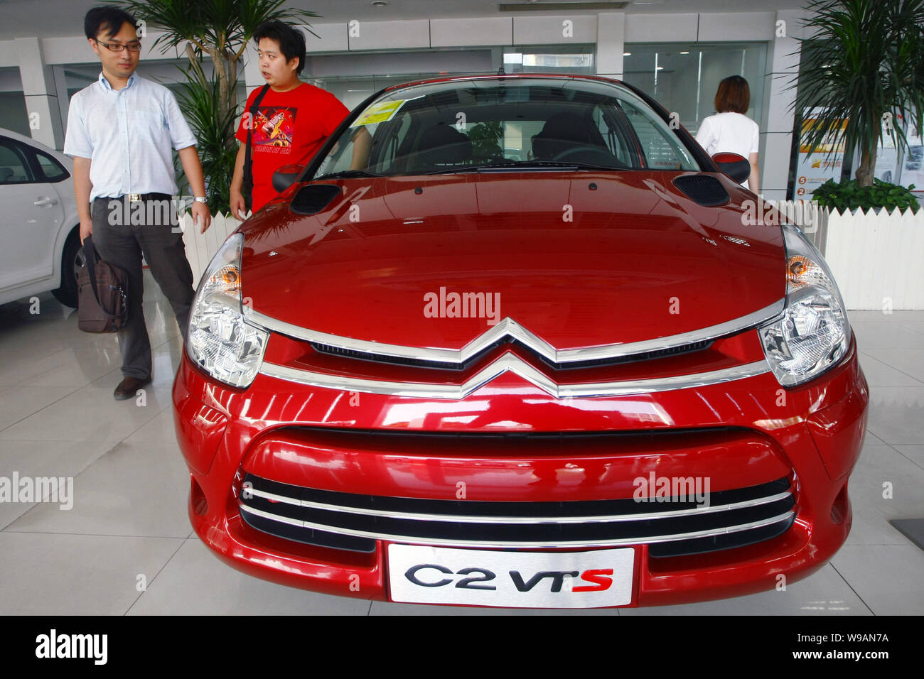 Chinese car buyers look at a Dongfeng Citroen C2 VTS at a Dongfeng Citroen dealership in Shanghai, China, September 8, 2010.   Volkswagen AG and PSA P Stock Photo