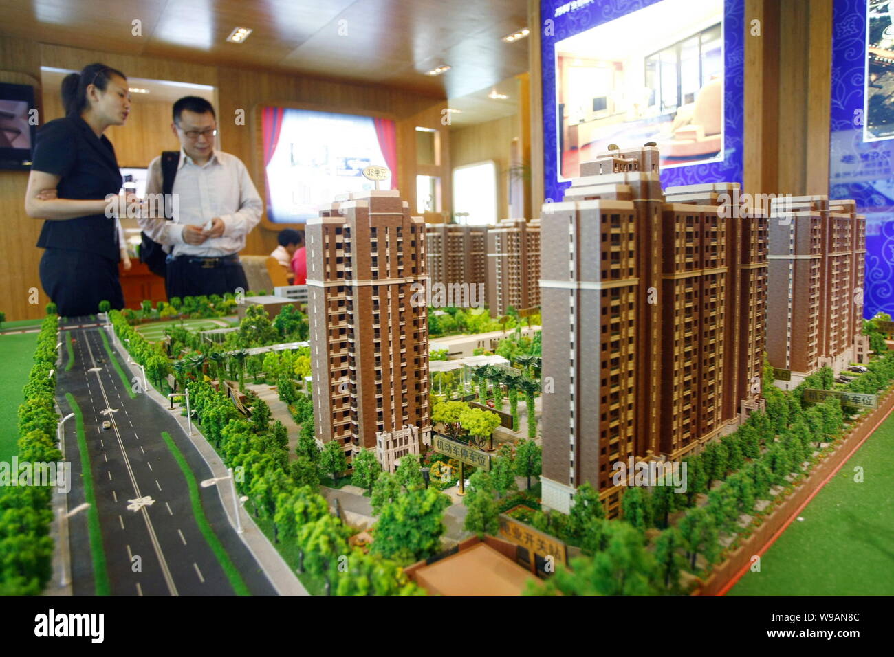 --FILE--A Chinese saleswoman introduces a residential project to a homebuyer during a real estate fair in Shanghai, China, 16 July 2010.   Sales of ne Stock Photo
