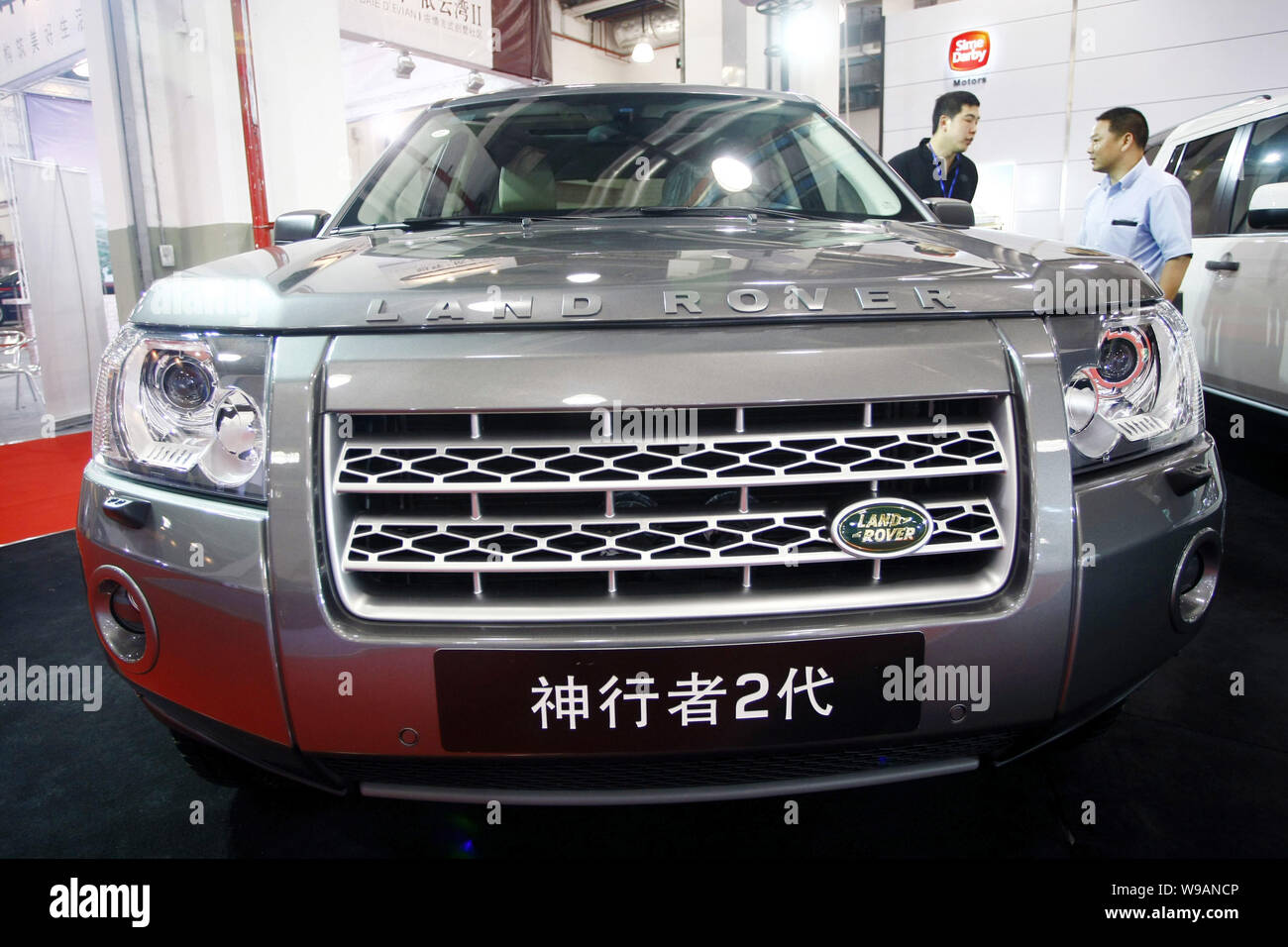 --FILE--A Chinese car buyer talks with a salesman next to a Land Rover Freelander 2 in a dealership in Shanghai, China, 11 June 2010.   Luxury SUV bra Stock Photo