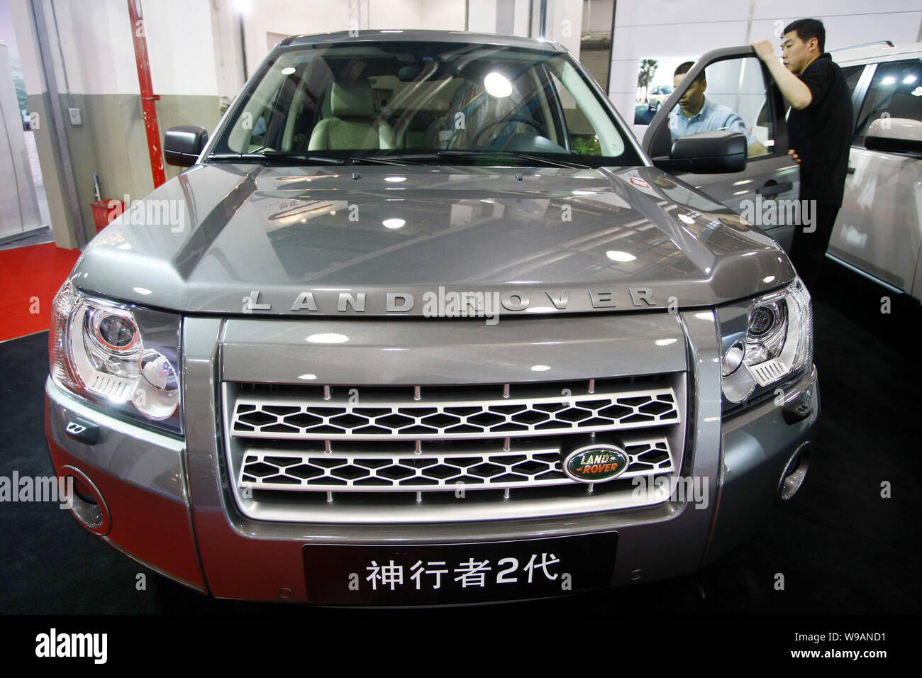 --FILE--A Chinese salesman introduces a Land Rover Freelander 2 to a car buyer in a dealership in Shanghai, China, 11 June 2010.   Luxury SUV brand La Stock Photo