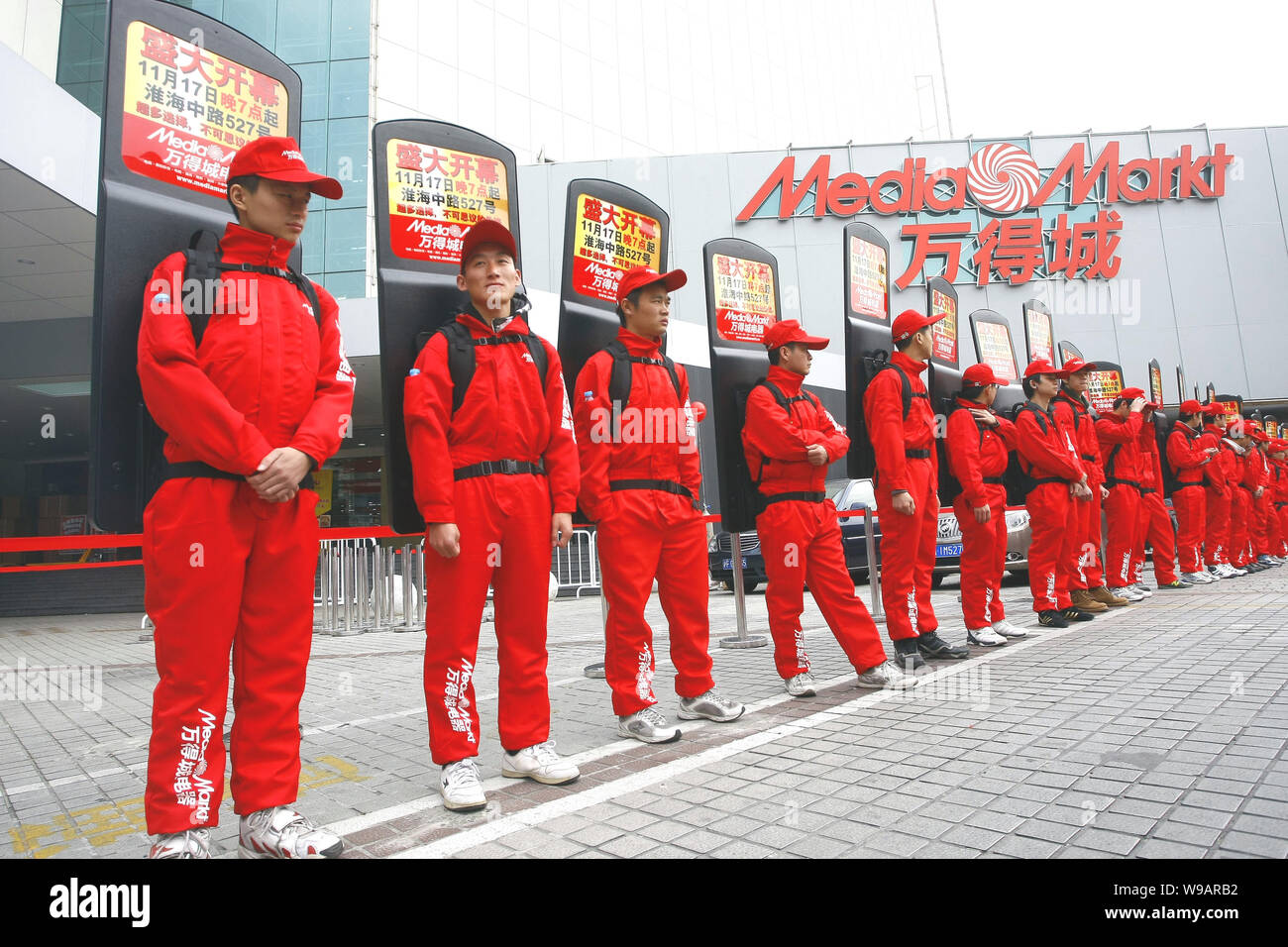 Chinese staff with advertisement on their back prepare for the opening of  the Media Markt store in Shanghai, China, November 17, 2010. Leading Europ  Stock Photo - Alamy