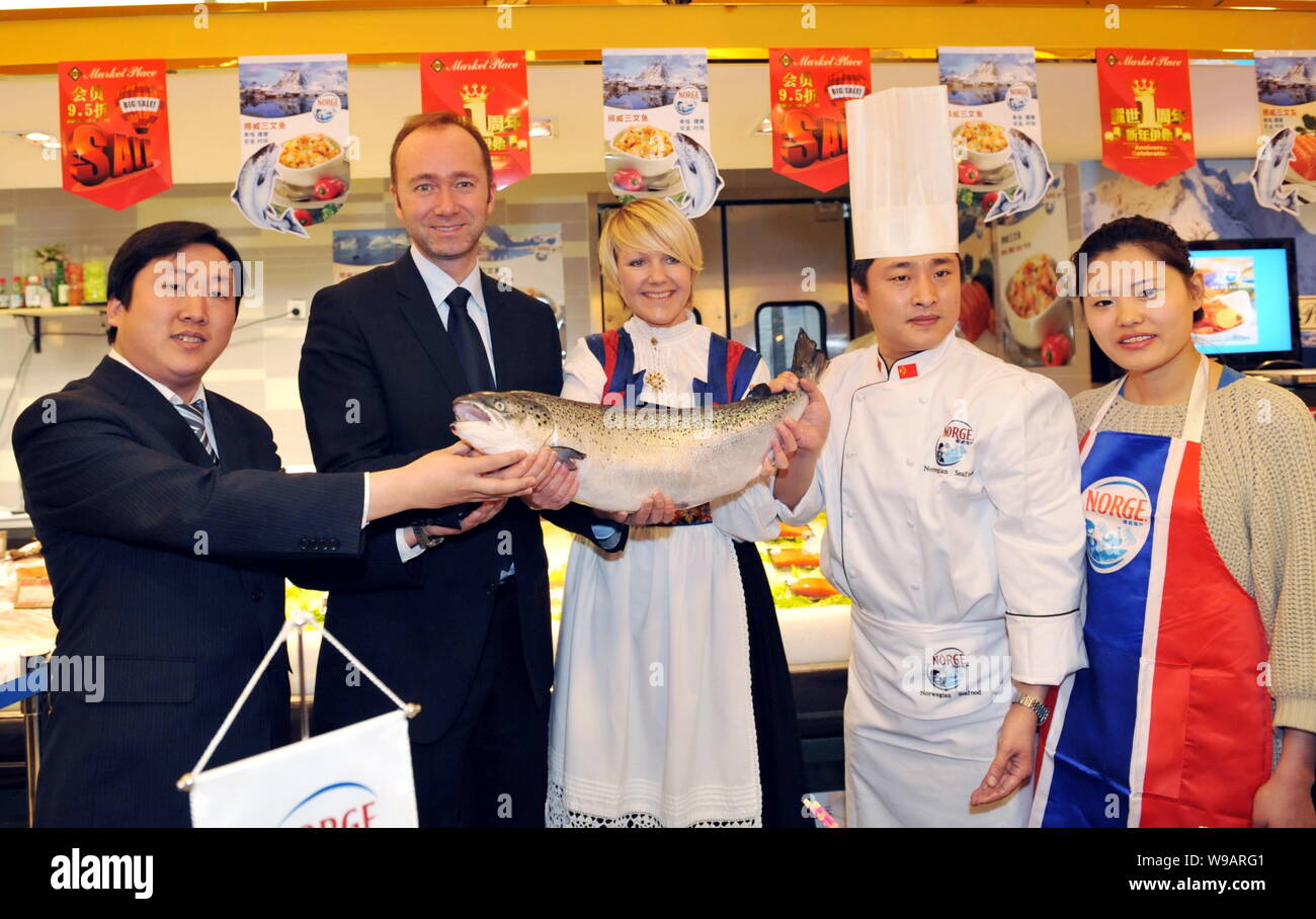 Trond Giske, second left, Minister of Trade and Industry of Norway, and other people hold a salmon from Norway during his visit to a supermarket in Be Stock Photo