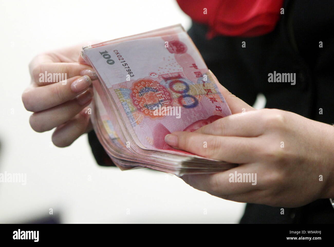--FILE--A Chinese bank clerk counts RMB (renminbi) yuna banknotes at the headquarters of HSBC China in the Lujiazui Financial District in Pudong, Shan Stock Photo