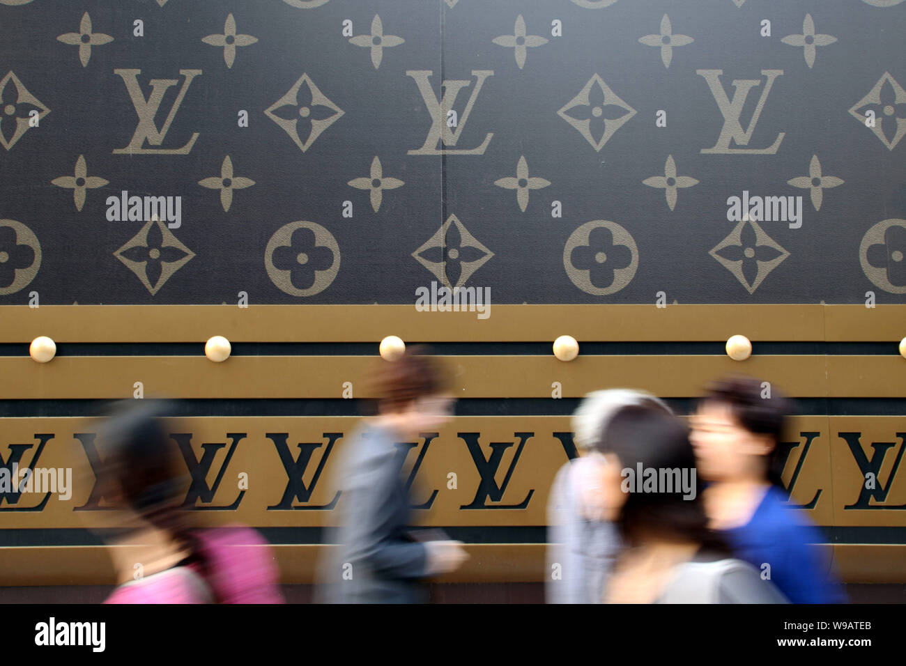 A trendy young woman carrying a Louis Vuitton (LV) handbag walks past a  huge LV suitcase outside the Plaza 66 shopping mall in Shanghai, China, 4  Nove Stock Photo - Alamy