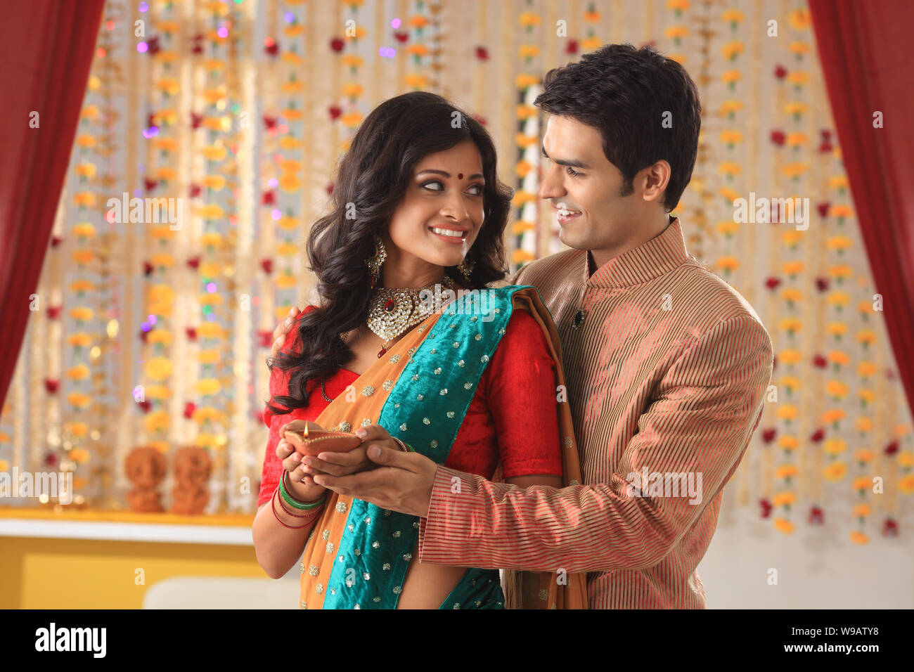 Young couple holding a diya and smiling Stock Photo