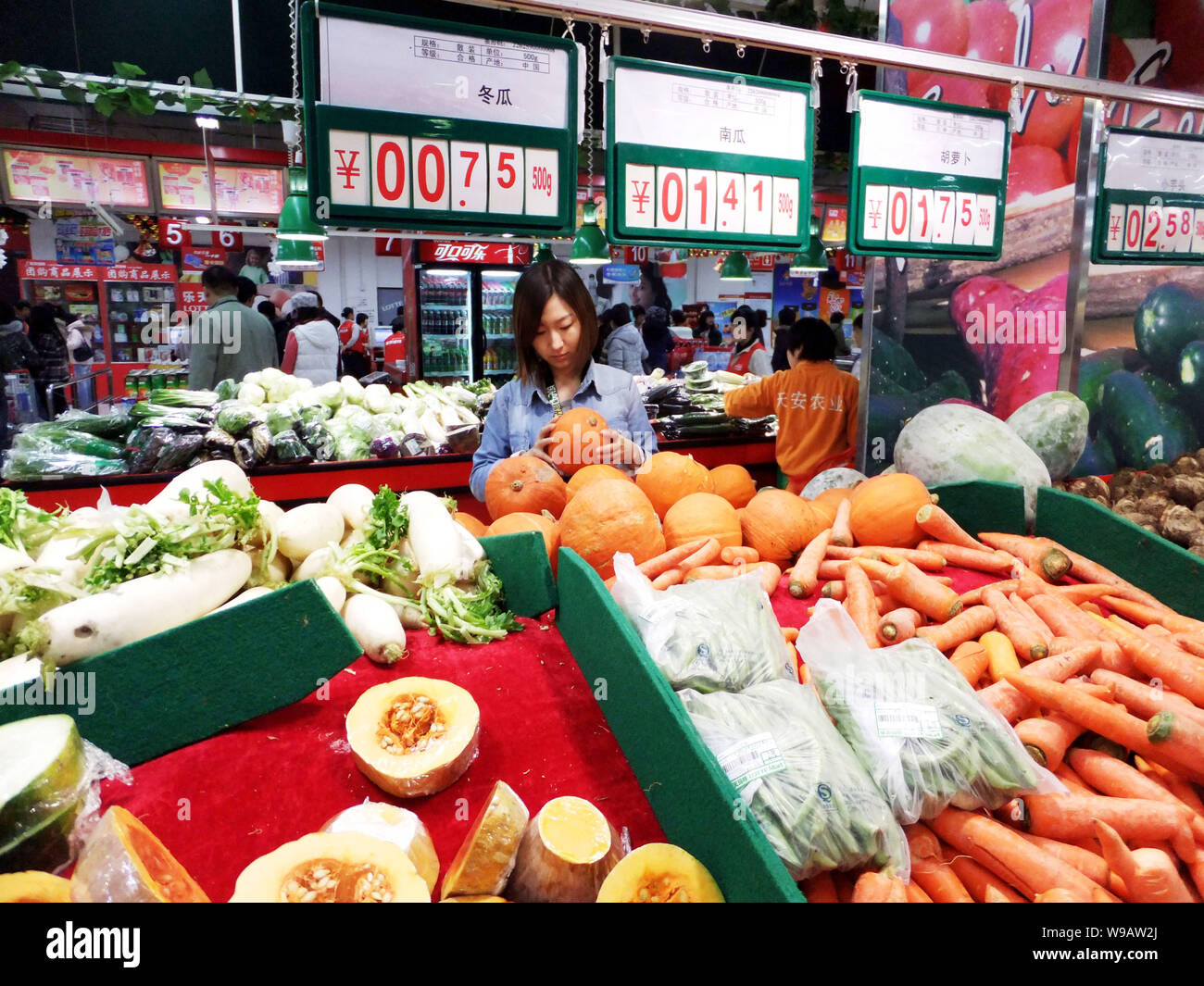 Chinese customers shop for vegetables at a supermarket in Beijing