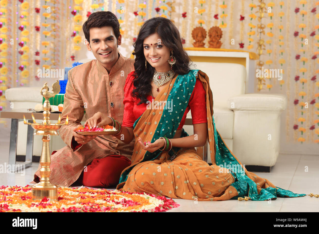 Young couple making rangoli Stock Photo