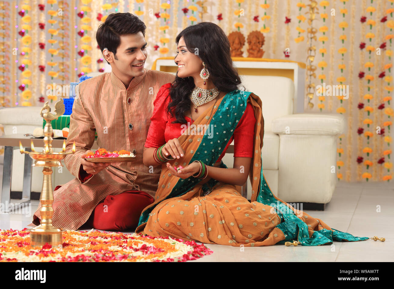 Young couple making rangoli Stock Photo