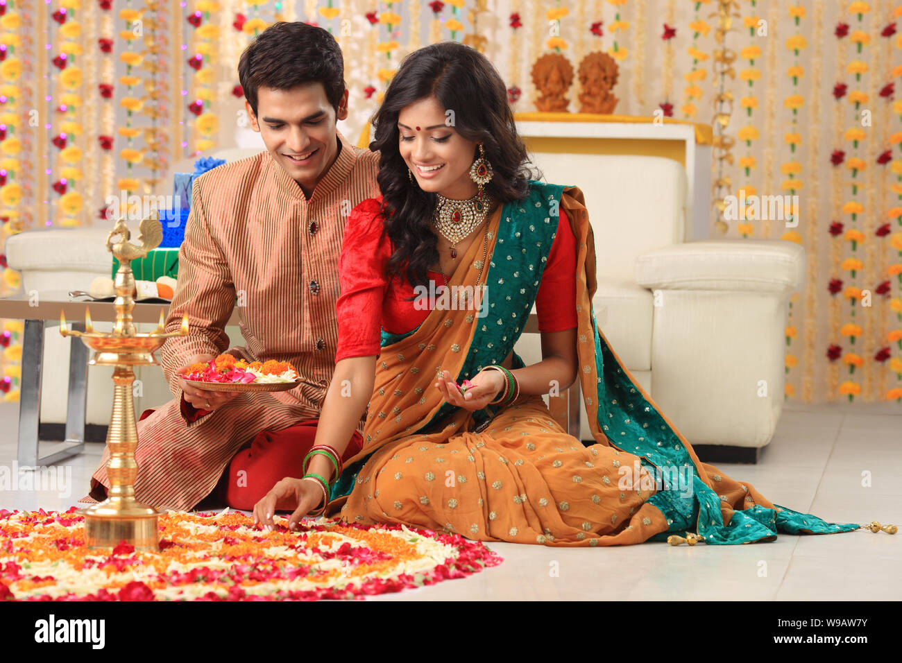 Young couple making rangoli Stock Photo