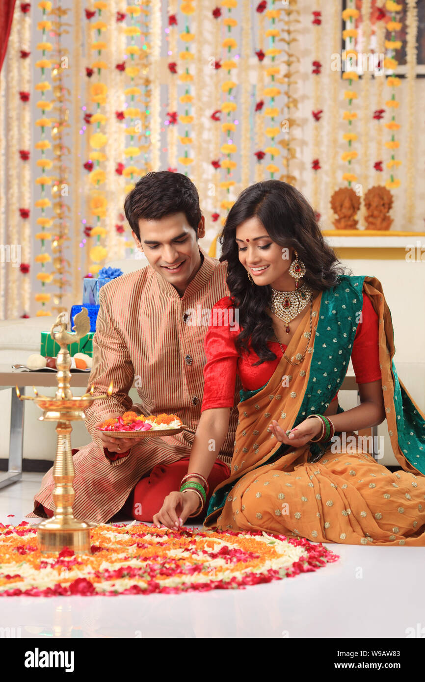 Young couple making rangoli Stock Photo - Alamy