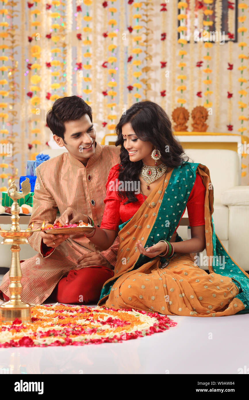 Young couple making rangoli Stock Photo