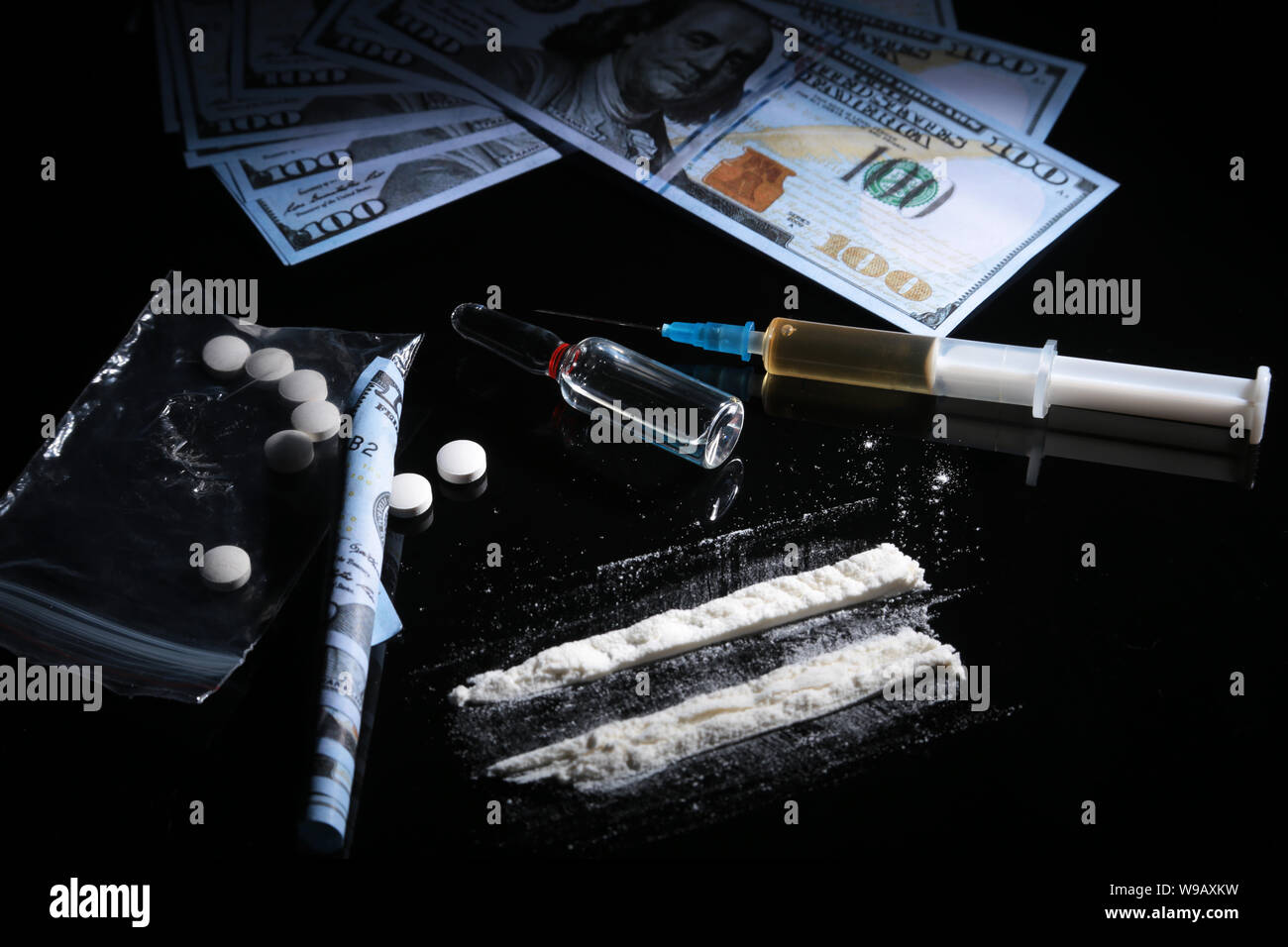 drug trafficking, crime, addiction and sale concept - closeup of with drugs and money. Stock Photo