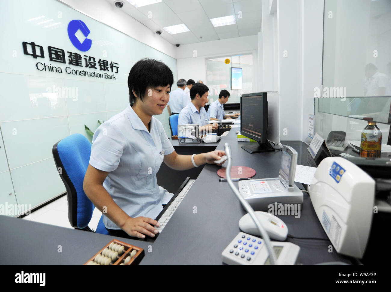 FILE--Chinese bank clerks work in a branch of China Construction Bank (CCB)  in Haian county, Nantong city, east Chinas Jiangsu province, 6 August 20  Stock Photo - Alamy