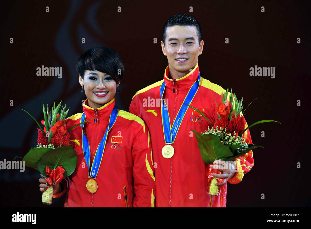 Chinas Shi Lei, left, and Zhang Baiyu (gold medalists) pose on the podium during the award ceremony for the dance sport latin five-dance final at the Stock Photo