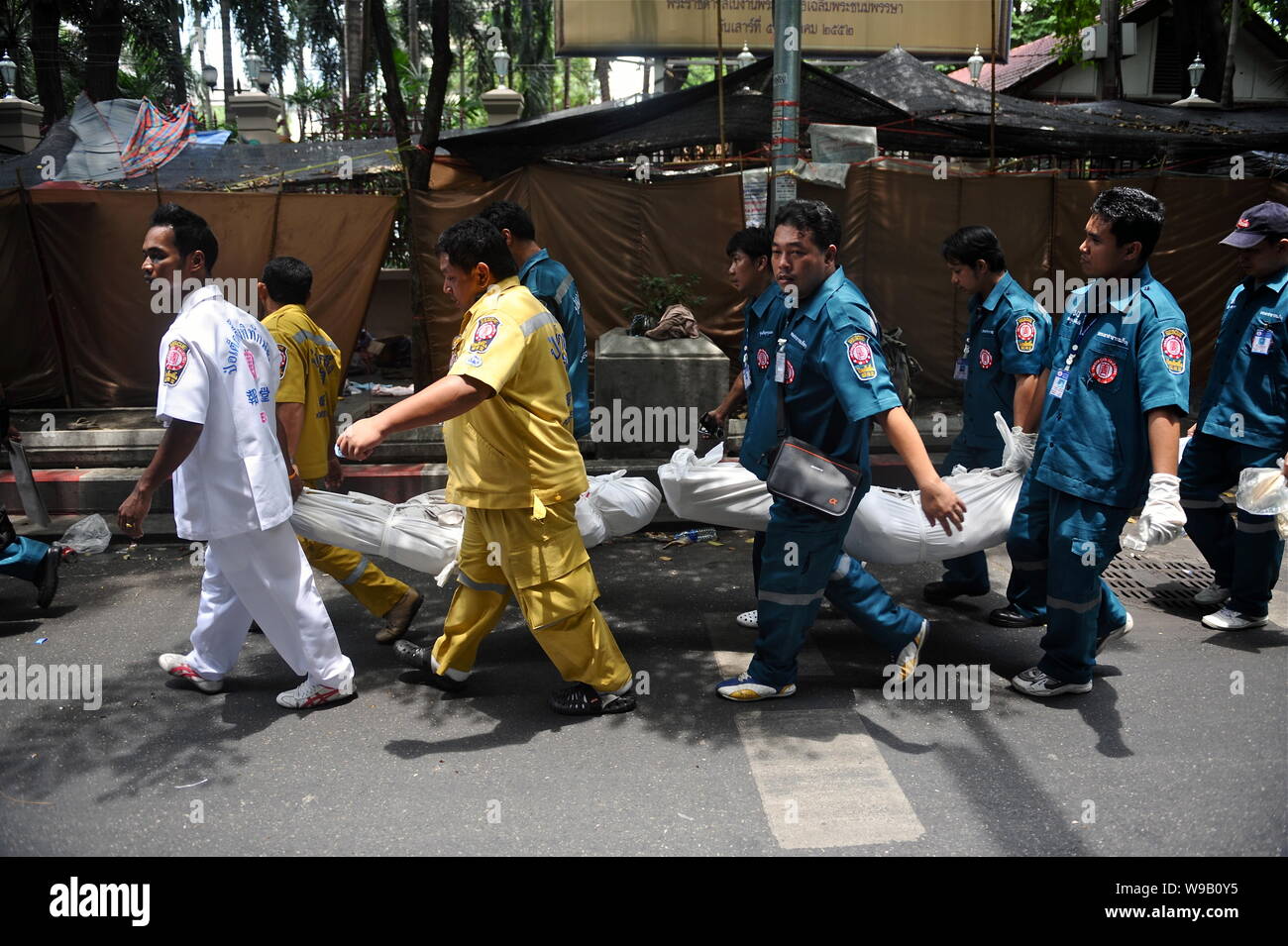 Thai medical workers carry the bodies of anti-goverment protesters on the street in Bangkok, Thailand, 20 May 2010. Stock Photo