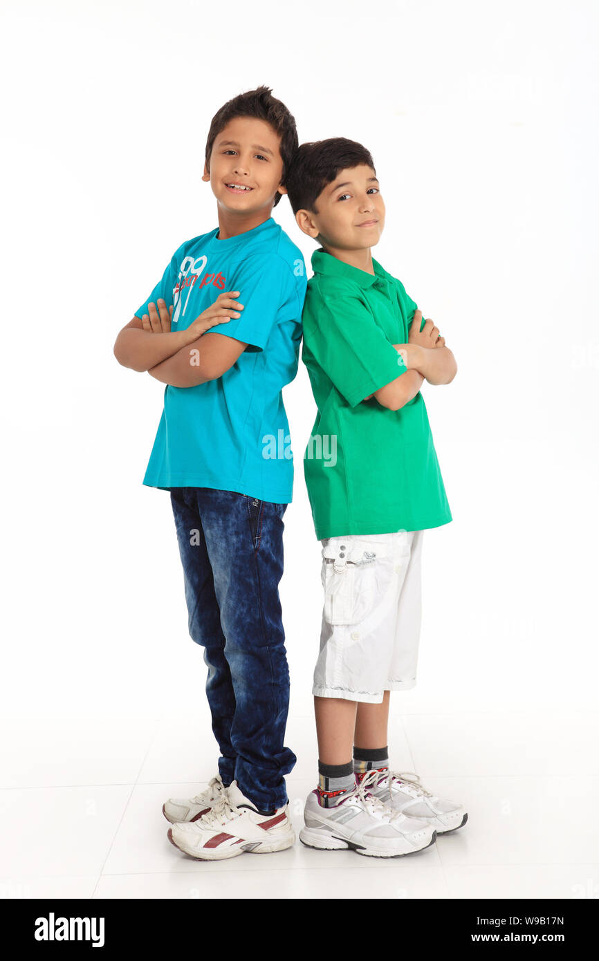 Two boys standing together back to back Stock Photo