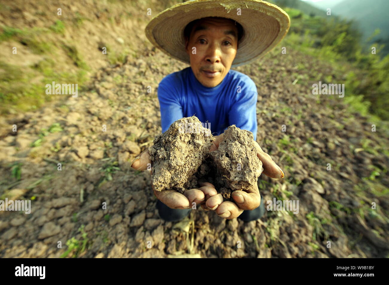 A Chinese farmer shows dried soil in his filed during a severe drought in Sanhe town, Fengdu county, southwest Chinas Chongqing Municipality, 21 March Stock Photo