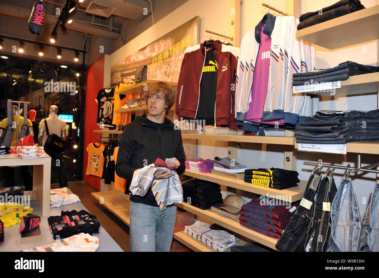German F1 driver Sebastian Vettel of Red Bull chooses clothes at a Puma  store in Shanghai, China, April 15, 2010. The Formula One Chinese Grand  Prix Stock Photo - Alamy