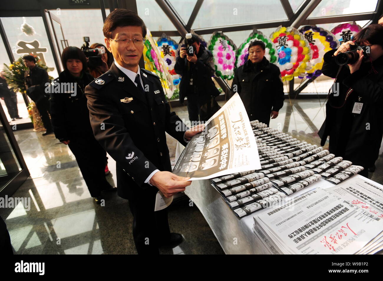 Meng Jianzhu, front, Minister of Public Security, reads the newspaper with portraits of the eight police officers who died in the Haiti earthquake dur Stock Photo