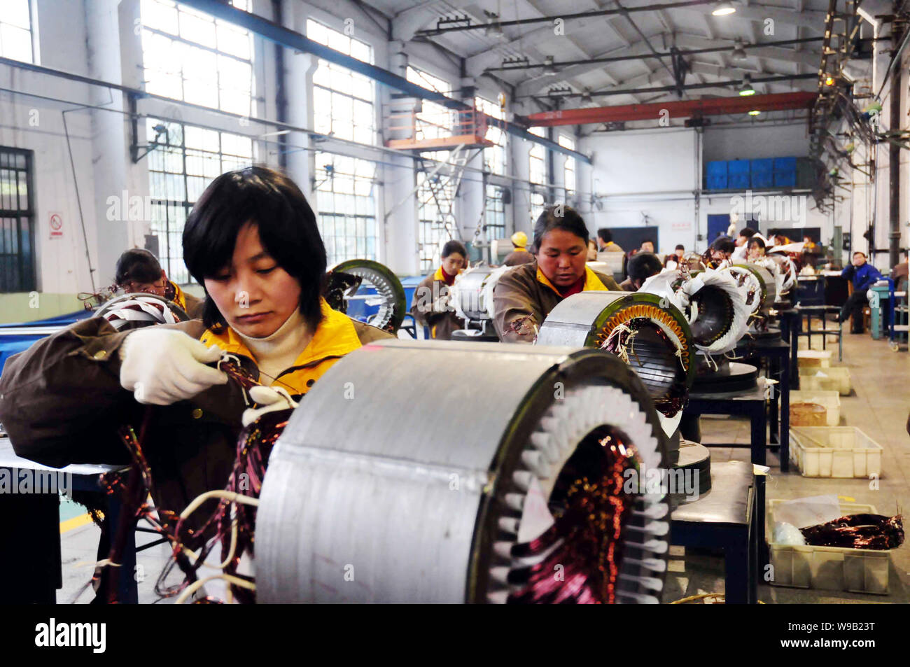 Chinese workers mount wires in the stators of explosion-proof motors in ...