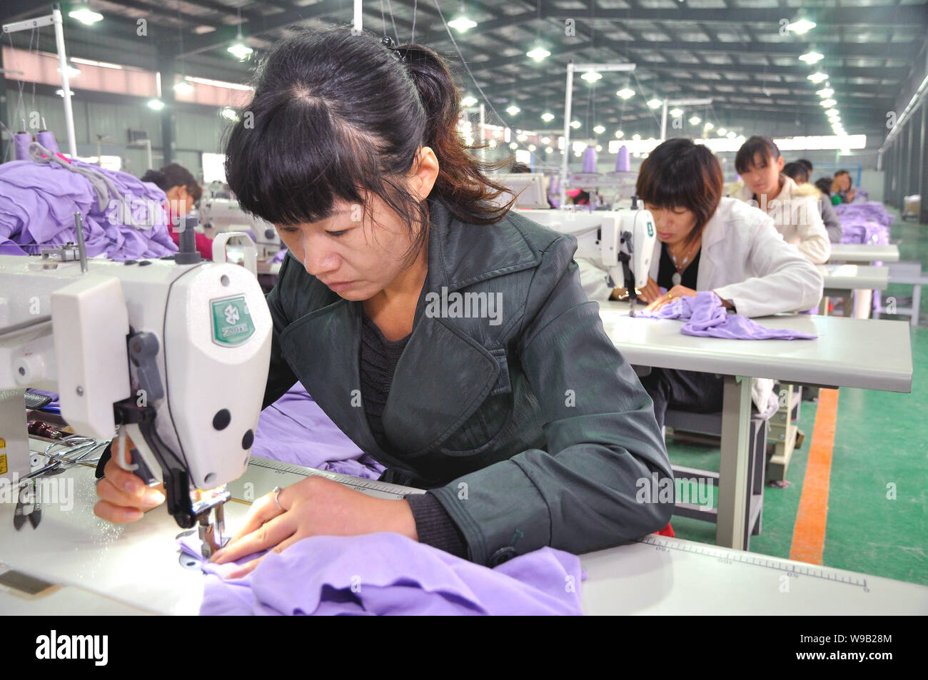 Female Chinese factory workers make clothes at a garment factory in Fuyang  city, east Chinas Anhui Province, October 12, 2010. Chinas textile manufa  Stock Photo - Alamy