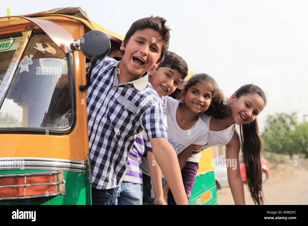 Group of children peeking out from an auto rickshaw Stock Photo