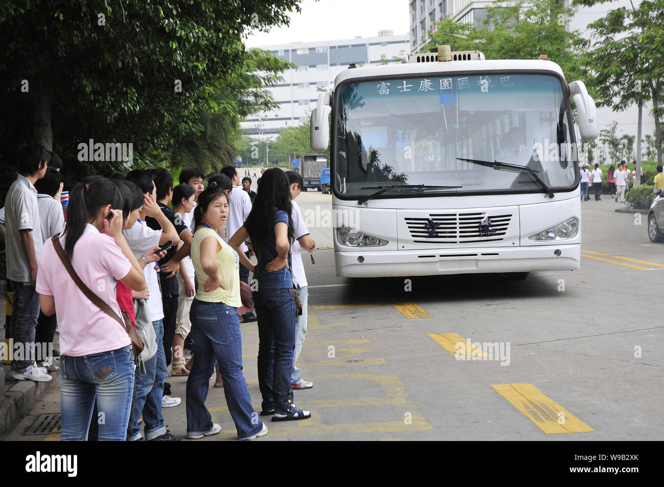 Chinese Foxconn employees wait for a shuttle bus in the Shenzhen plant of Foxconn Technology Group in Shenzhen city, south Chinas Guangdong province, Stock Photo