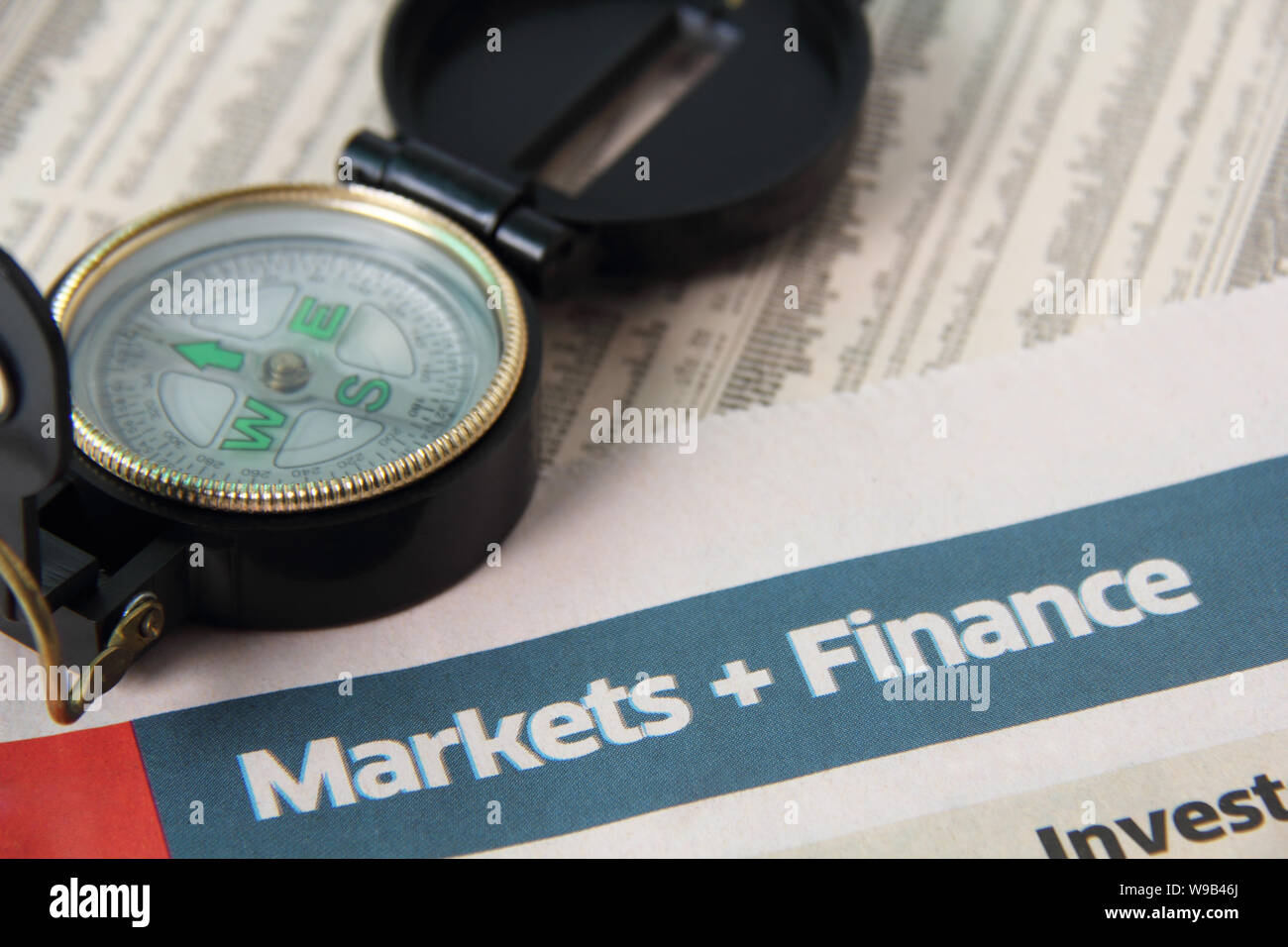 Close up of financial newspaper with compass Stock Photo