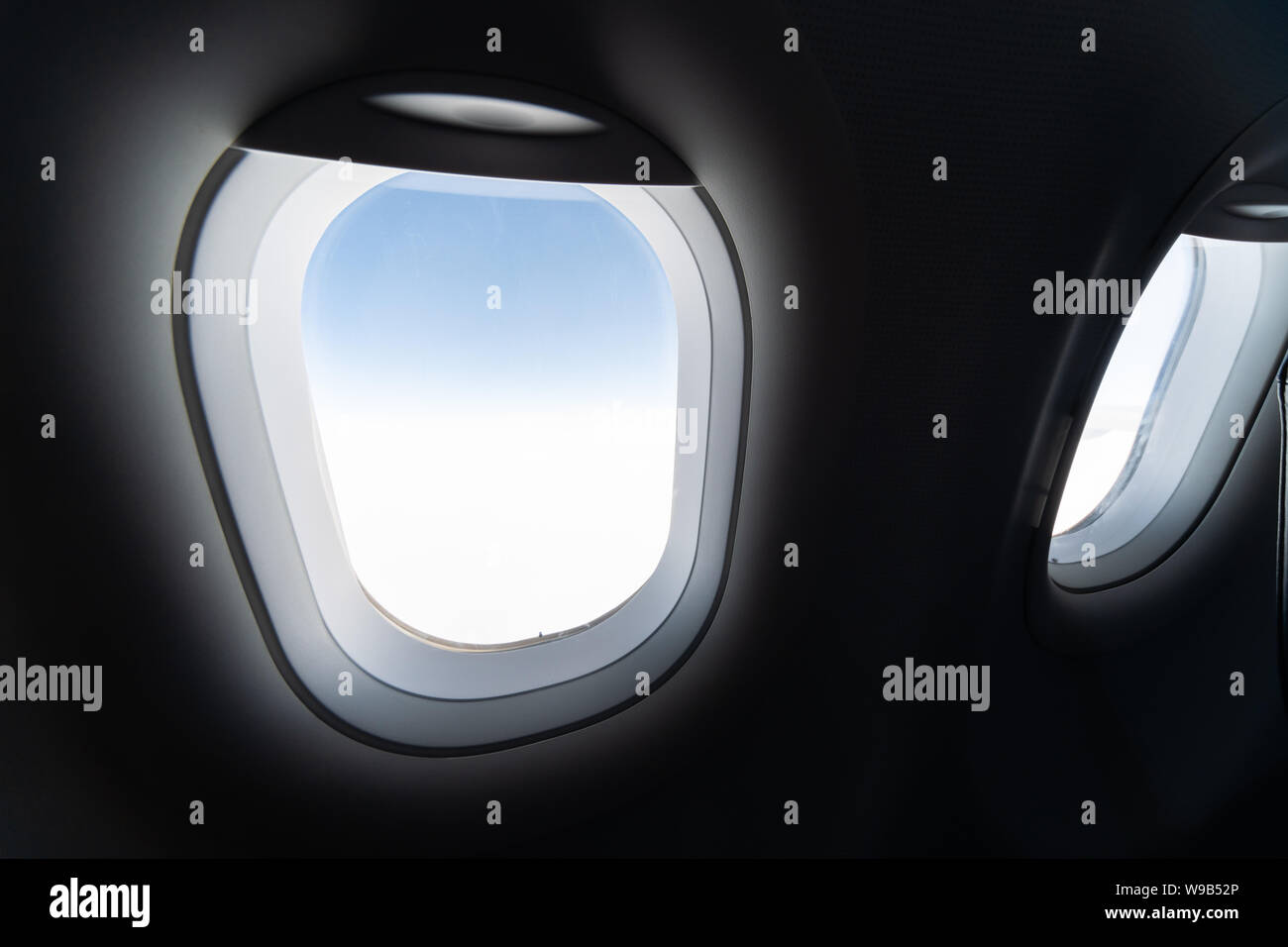 Airplane window view to cloudy sky and earth. Beautiful landscape from aircraft cabin. Flying without fear of flying, incidents and turbulence. Stock Photo
