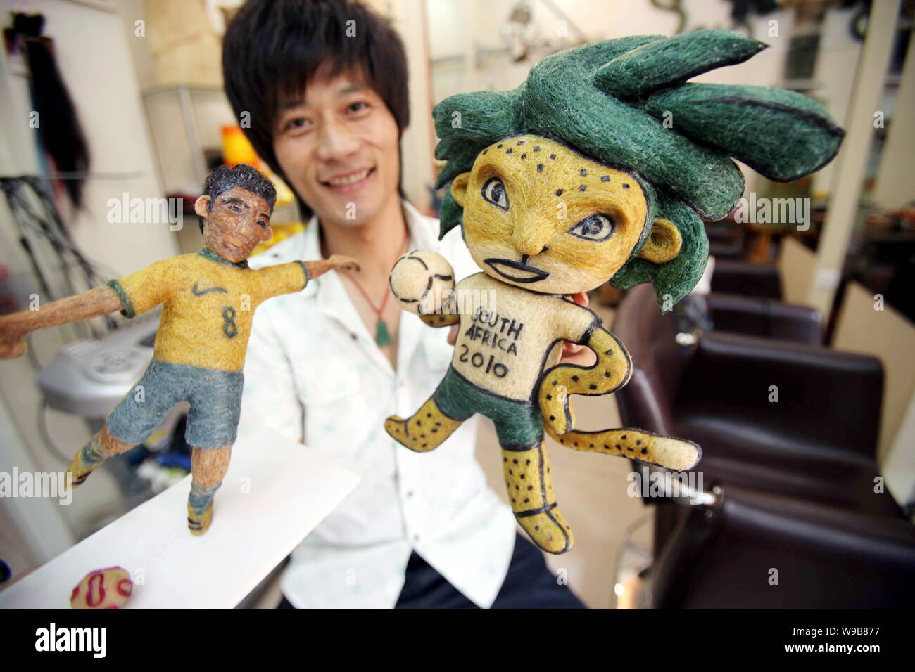Chinese hairstylist Huang Xin shows his hair-made football player and Zakumi, the official mascot of the World Cup South Africa 2010, in a hair salon Stock Photo