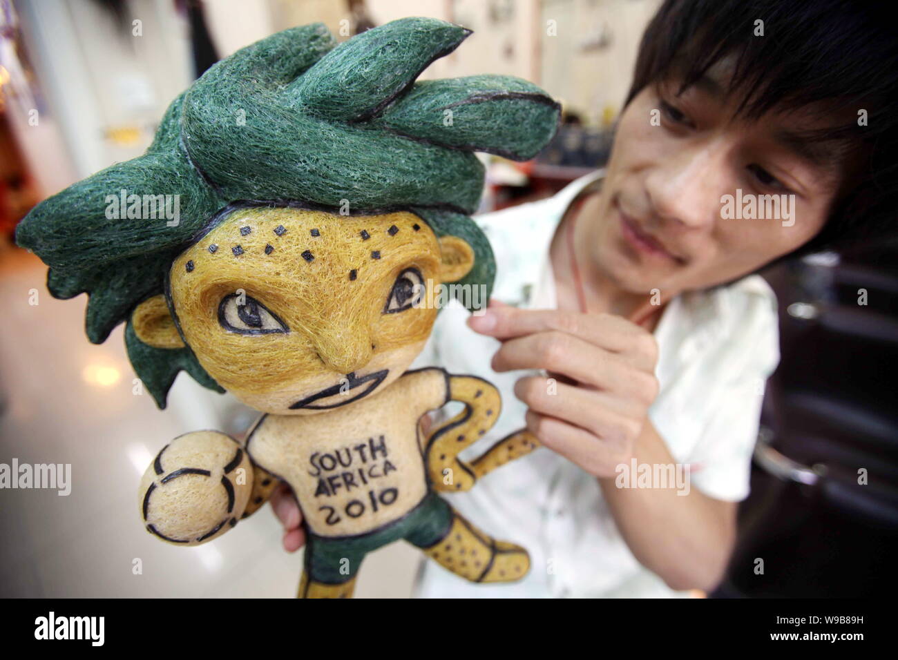 Chinese hairstylist Huang Xin shows his hair-made Zakumi, the official mascot of the World Cup South Africa 2010, in a hair salon in Beijing, China, 1 Stock Photo