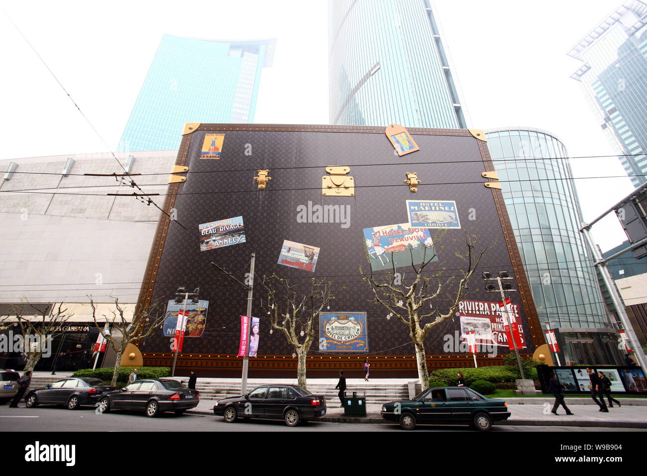 A trendy young woman carrying a Louis Vuitton (LV) handbag walks past a  huge LV suitcase outside the Plaza 66 shopping mall in Shanghai, China, 4  Nove Stock Photo - Alamy