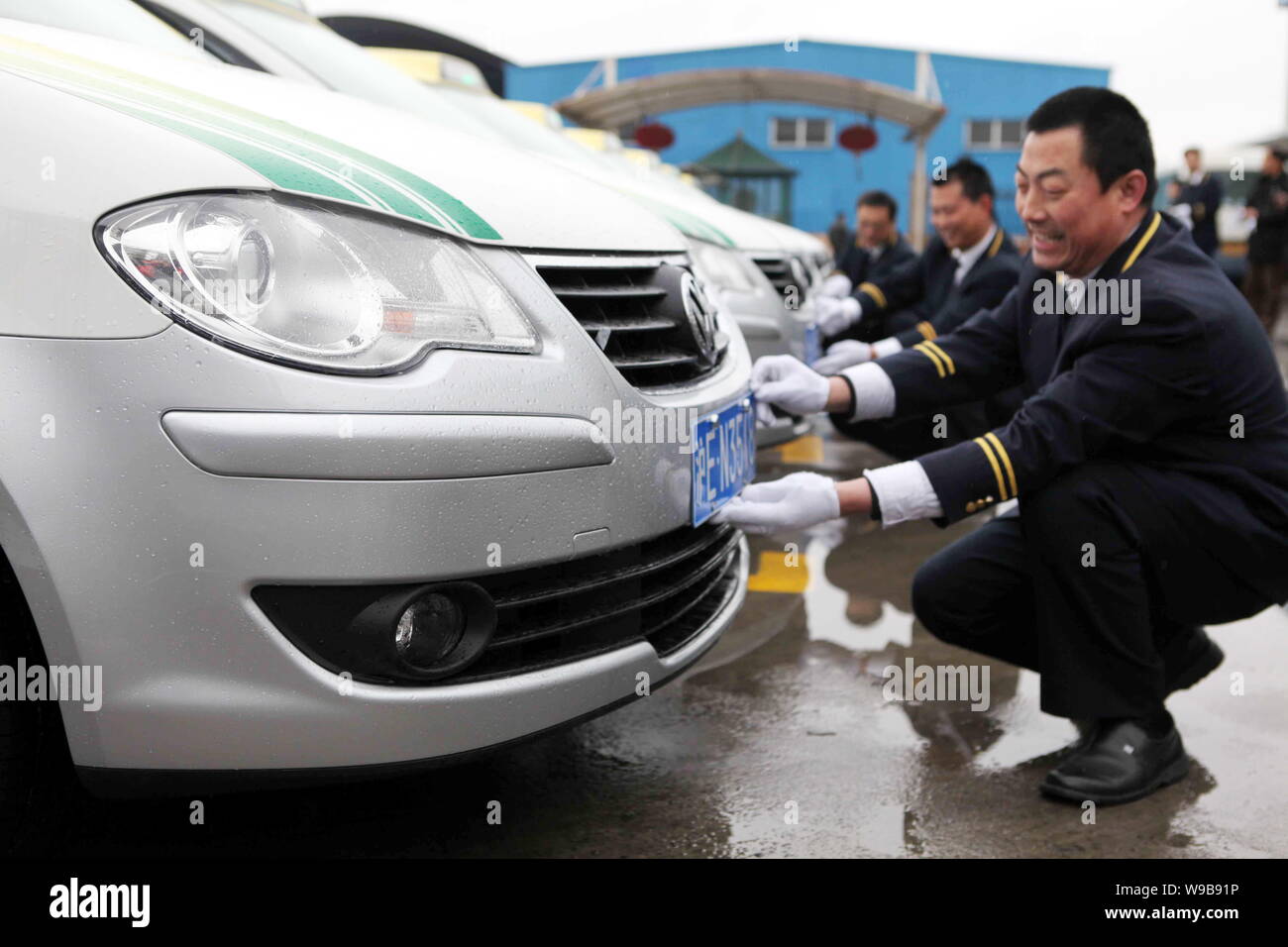Chinese taxi drivers put license plates on the Volkswagen Touran taxis for the Expo 2010 at a parking lot in Shanghai, China, 24 March 2010.   Shangha Stock Photo