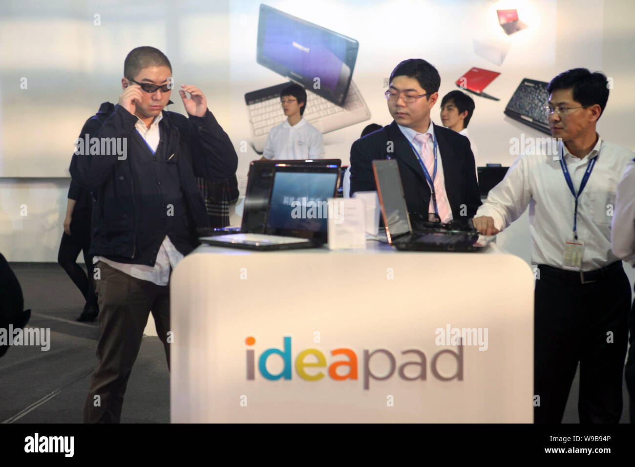 Visitors try Lenovo ideapad laptops during a press conference by Lenovo