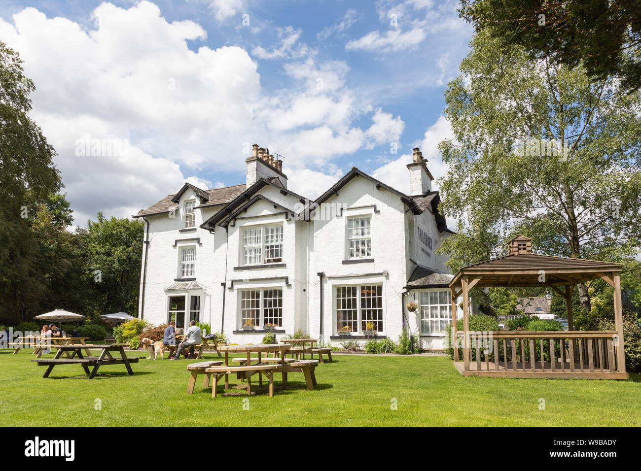 Grasmere, Cumbria, UK: Tweedies Bar and Lodge, a hotel, bar and restaurant, selling locally-brewed real ales. A garden contains tables and chairs. Stock Photo