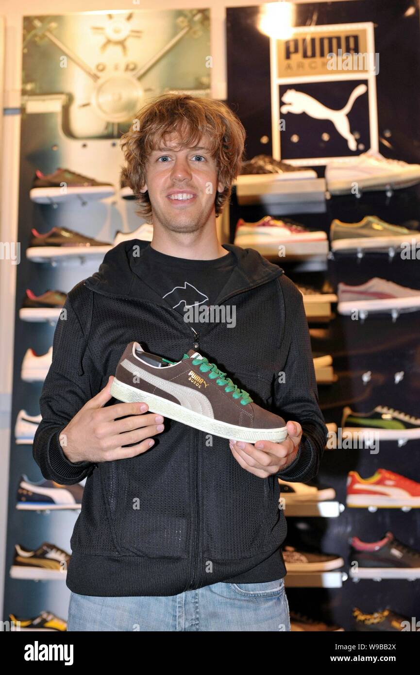 German F1 driver Sebastian Vettel of Red Bull team holds a shoe at a Puma store in Shanghai, China, April 15, 2010