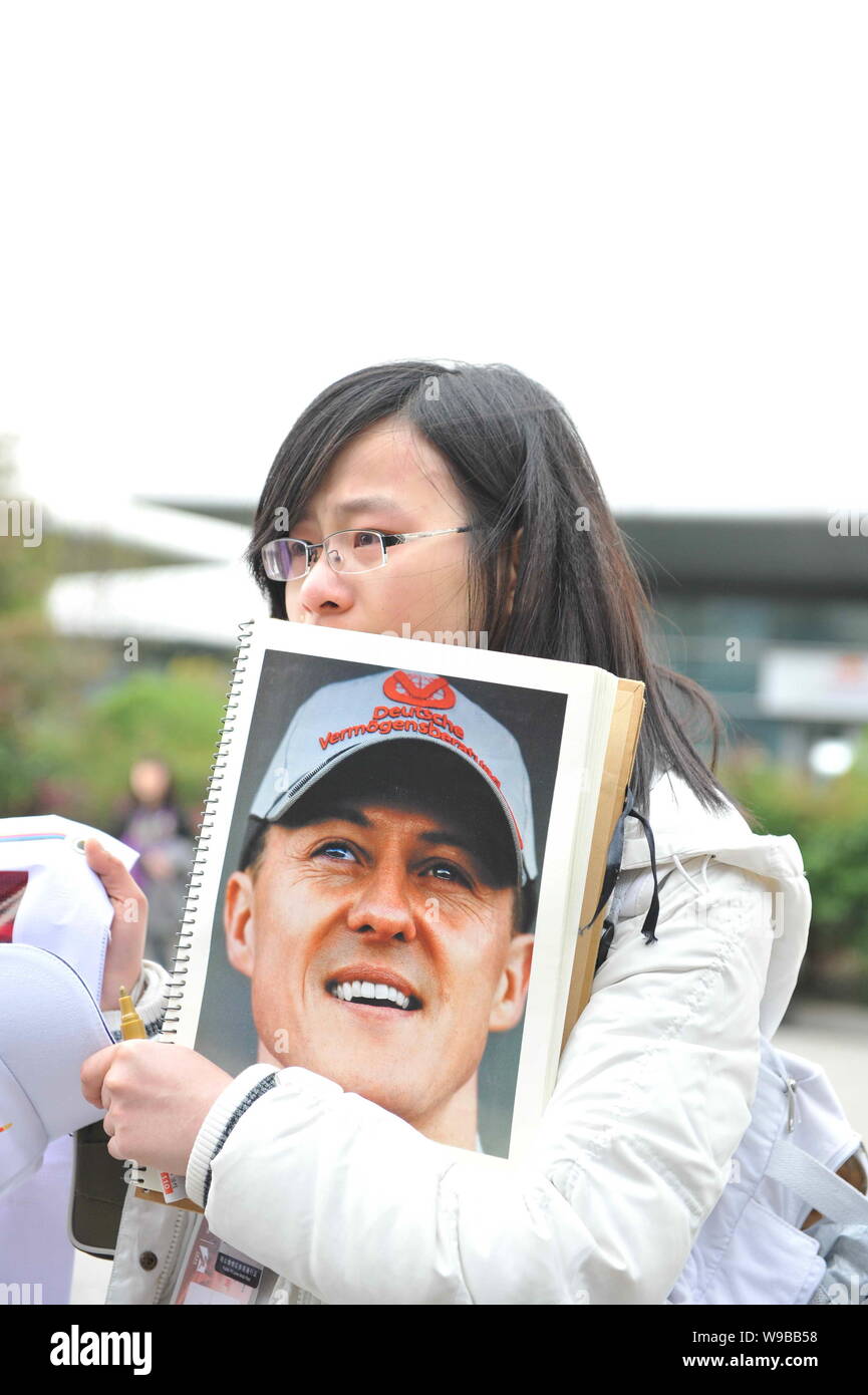A Chinese girl holds a photo of German F1 driver Michael Schumacher of Mercedes GP team to show her support at the Shanghai International Circuit in S Stock Photo