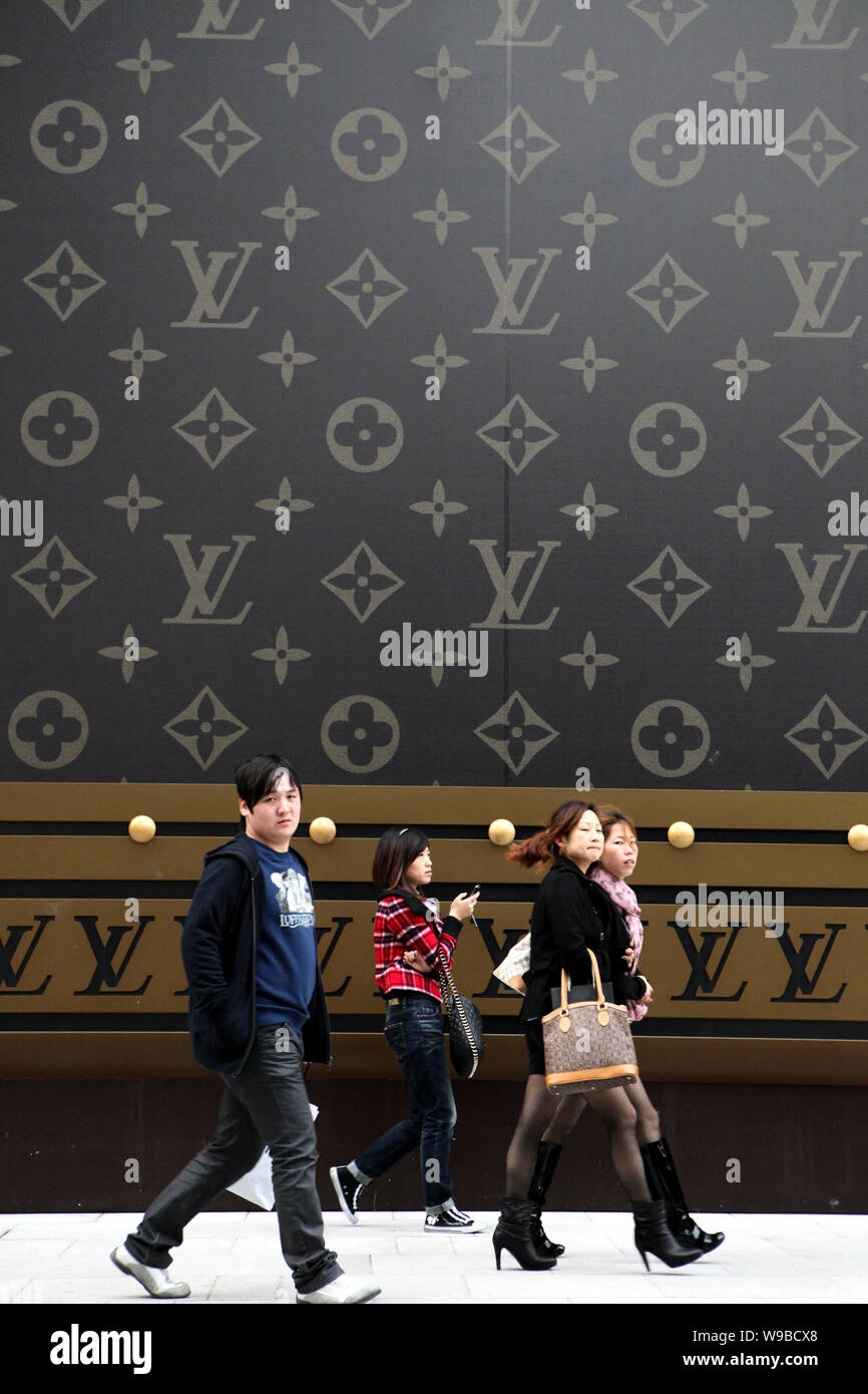 Young Chinese people walk past a huge Louis Vuitton (LV) suitcase outside  the Plaza 66 shopping mall in Shanghai, China, 4 November 2010. Chinas lux  Stock Photo - Alamy