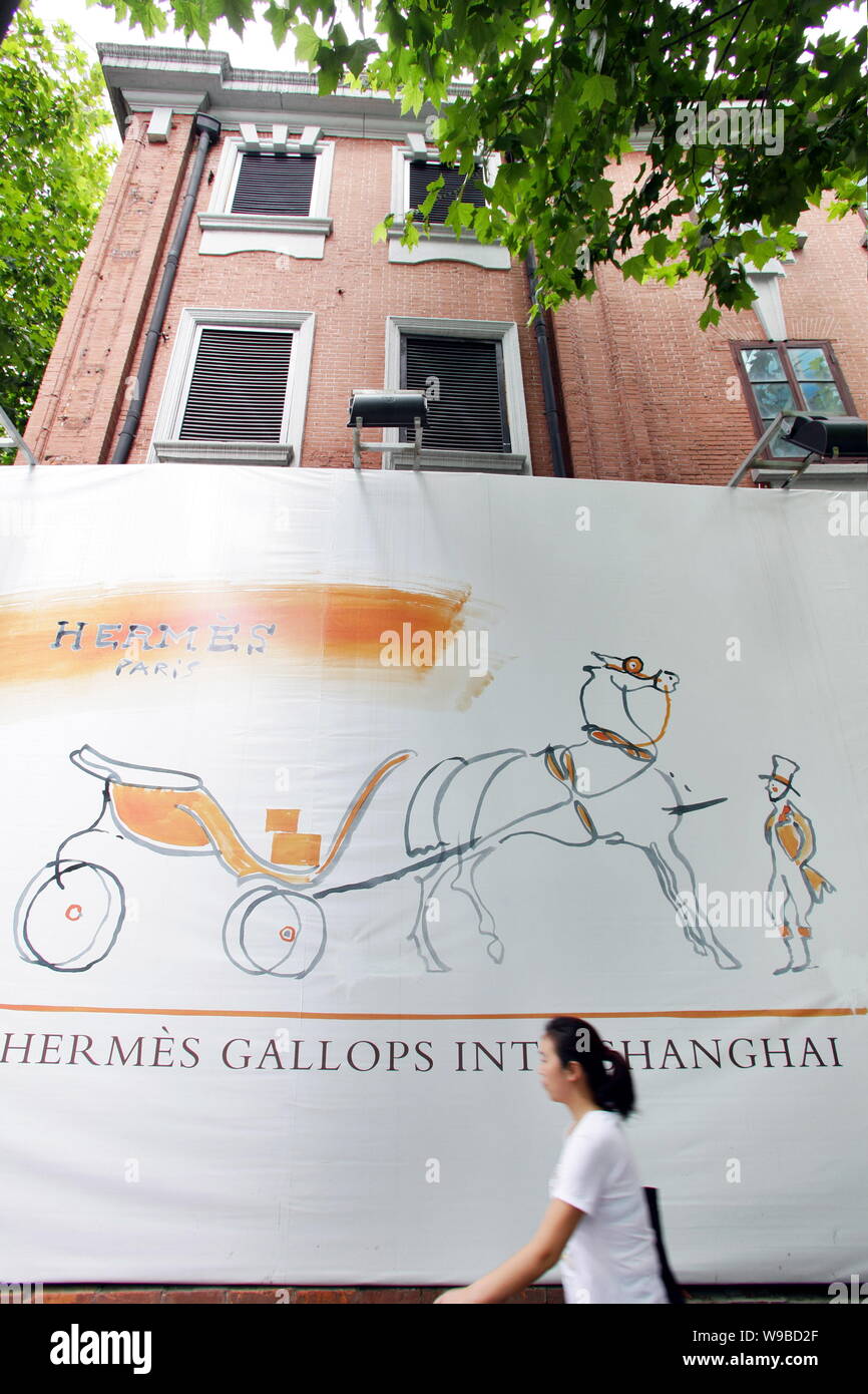 A Chinese Woman Walks Past An Advertisement For Hermes - 