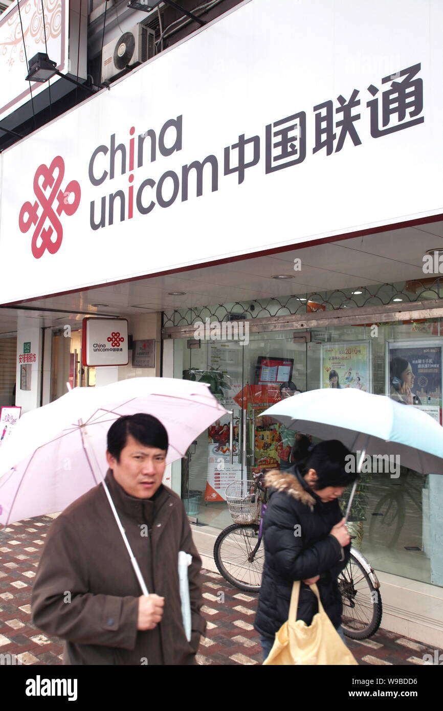 Local residents walk past a branch of China Unicom in Shanghai, China, March 8, 2010.   As if Apple does not have enough problems with iPhone and iPad Stock Photo