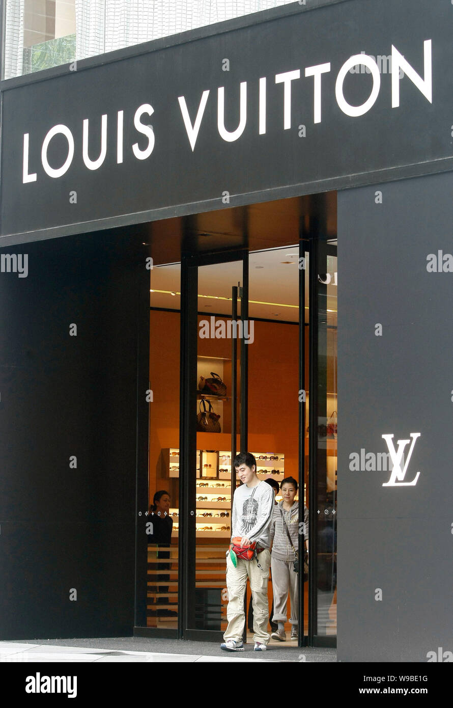 Customers leave a newly-opened Louis Vuitton (LV) flagship store