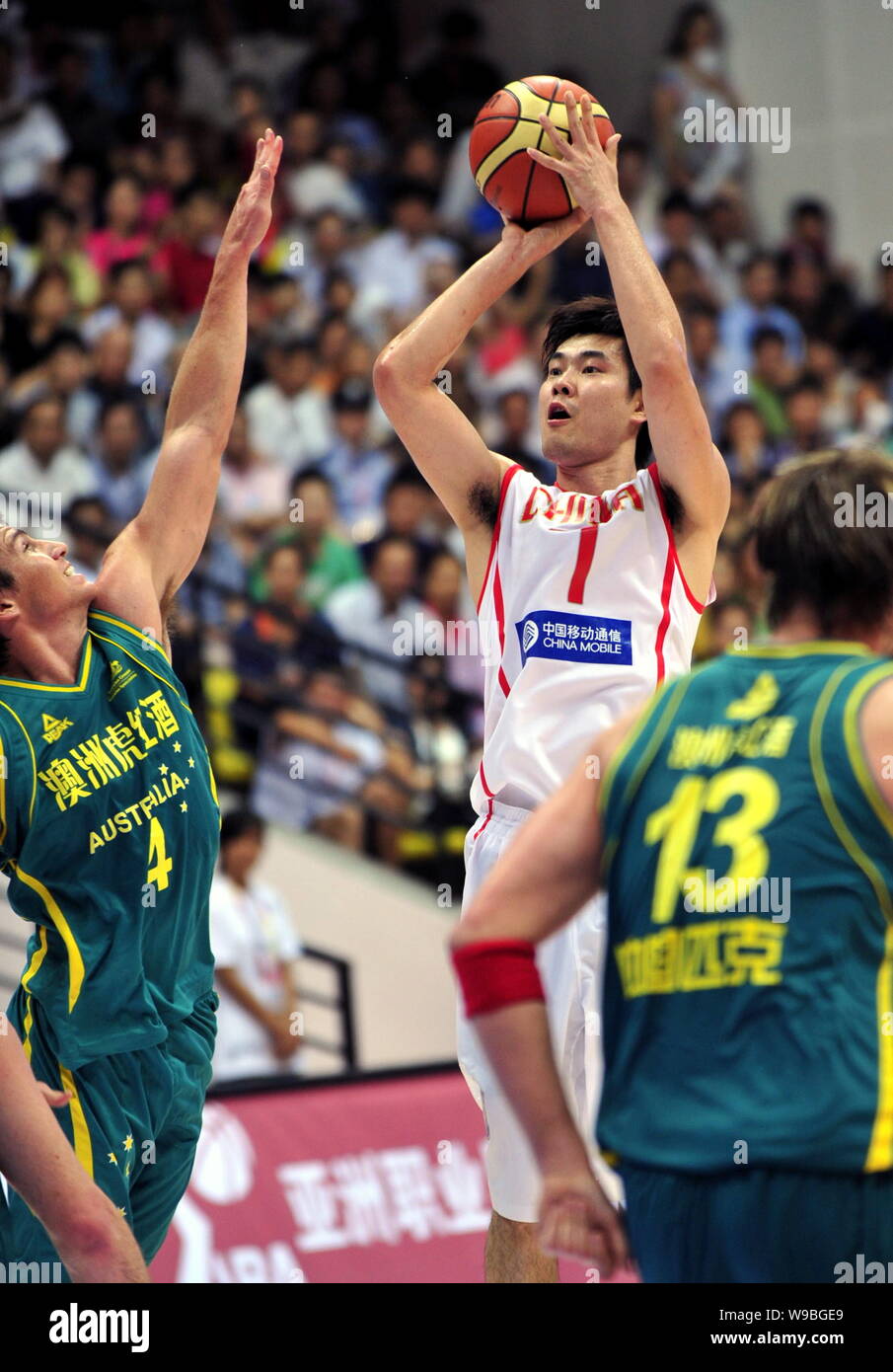 Chinese basketball player Wang Shipeng (central) shoots in a basketball ...