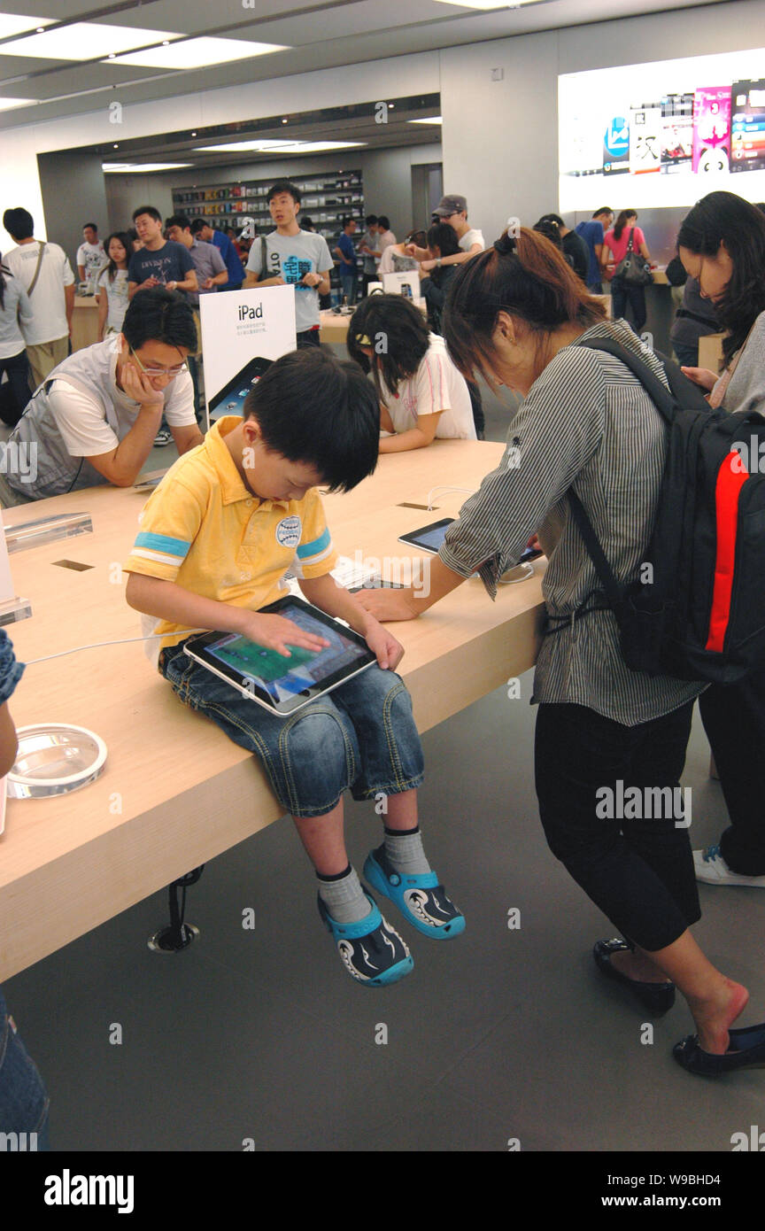 A young Chinese kid tries the iPad at the Apple store in the Lujiazui Financial District in Pudong, Shanghai, China, September 24, 2010.   Apple Inc. Stock Photo