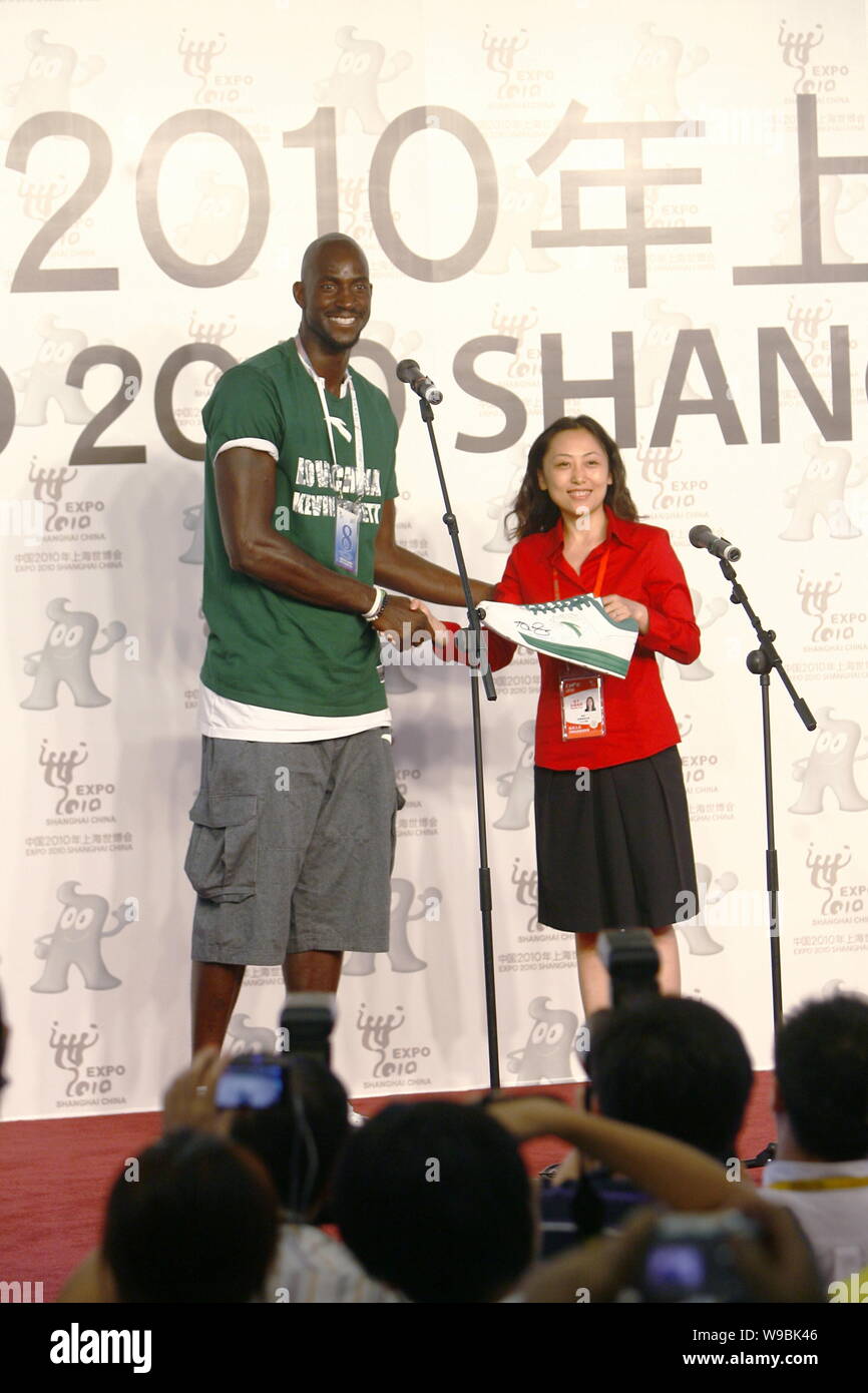 NBA basketball player Kevin Garnett of the Boston Celtics shakes hands with a Chinese foundation representative after presenting her a pair of sneaker Stock Photo