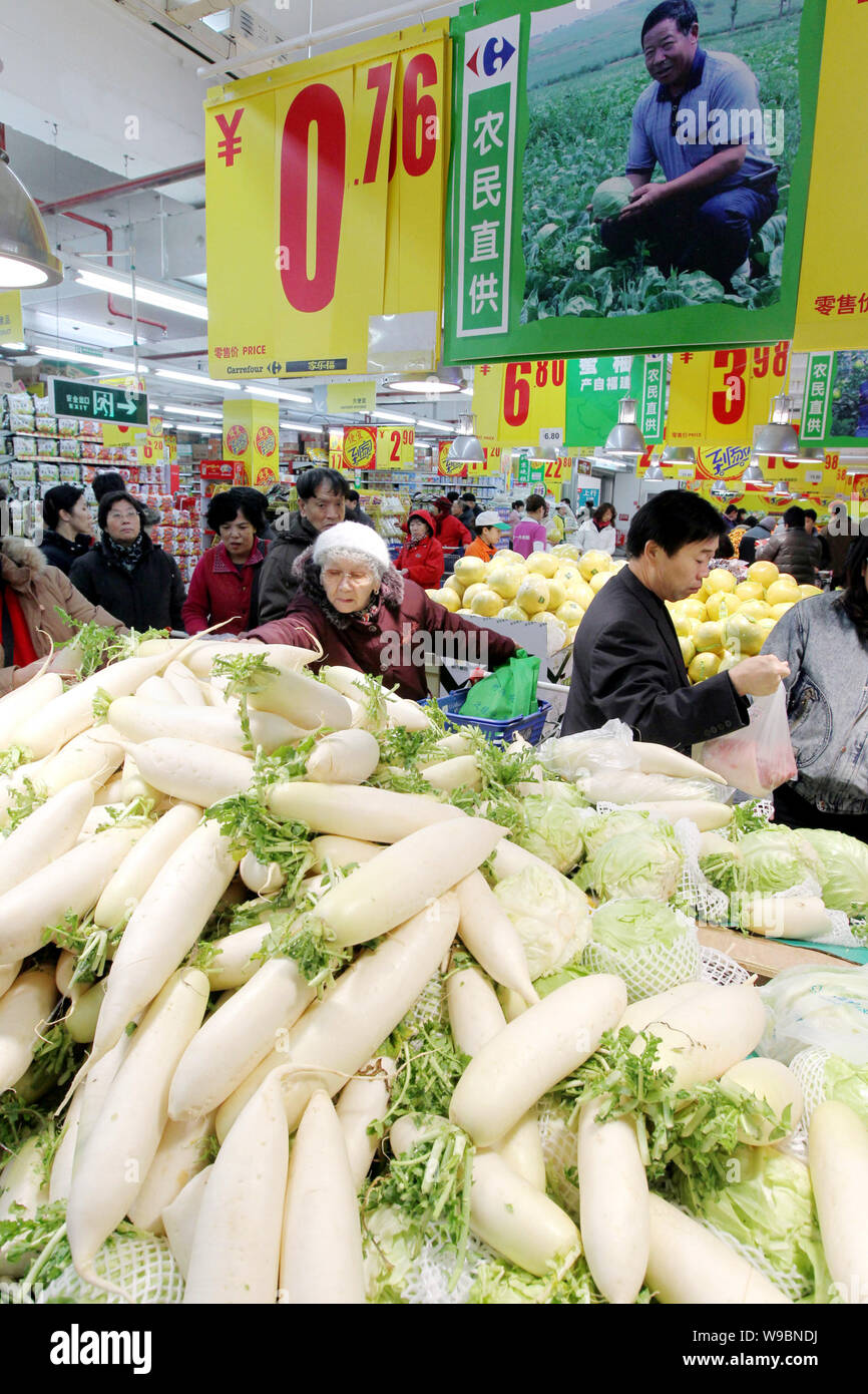 Chinese customers shop for radishes and other vegetables and fruits at a supermarket in Beijing, China, 11 December 2010.   China risks a more abrupt Stock Photo