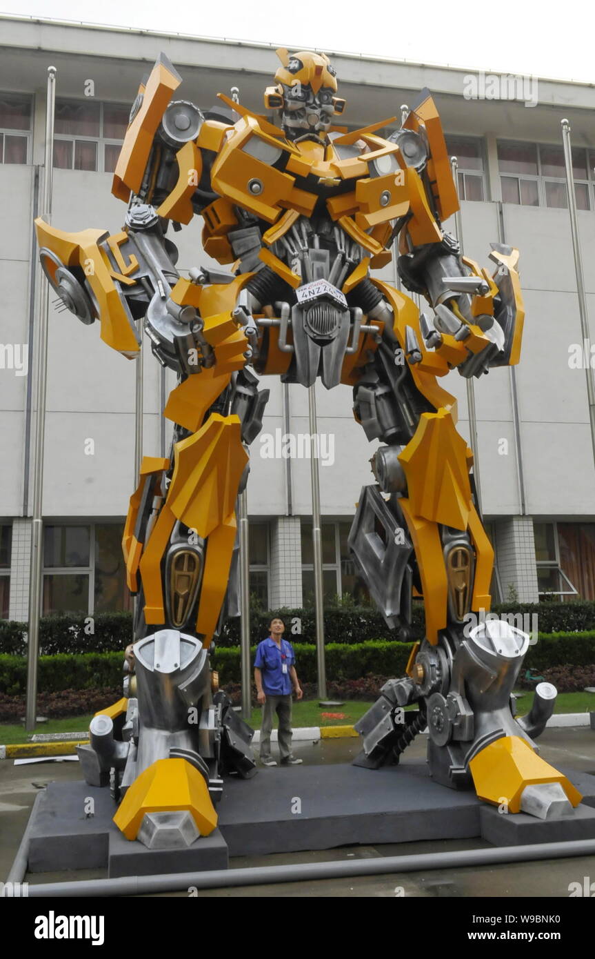 A Chinese worker looks at a model of the Bumblebee, one robot of the  Autobot in the movie Transformers, during the preparation for the  Transformers Cy Stock Photo - Alamy