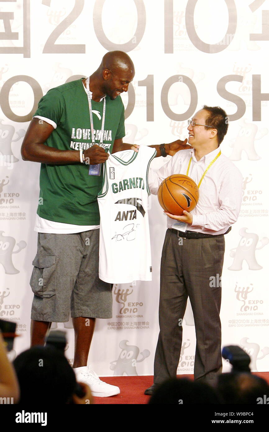 NBA basketball player Kevin Garnett of the Boston Celtics presents a jersey with his signature to a Chinese foundation representative during a press c Stock Photo